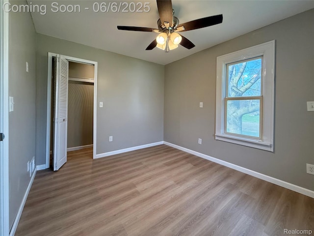 2105 Eberly Rd, Flint, MI 48532 - unfurnished bedroom with light wood-style flooring, baseboards, a closet, and a ceiling fan