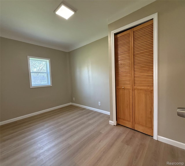 2105 Eberly Rd, Flint, MI 48532 - unfurnished bedroom featuring light wood-style floors, baseboards, and a closet