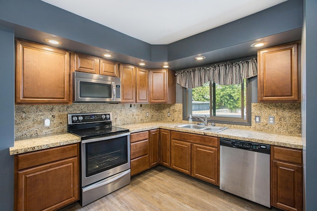 525 Riverview Ave, Monroe, MI 48162 - kitchen featuring stainless steel appliances, a sink, decorative backsplash, light wood-style floors, and recessed lighting