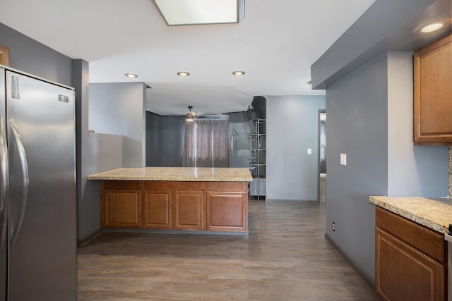 525 Riverview Ave, Monroe, MI 48162 - kitchen featuring freestanding refrigerator, a ceiling fan, wood finished floors, a peninsula, and brown cabinets