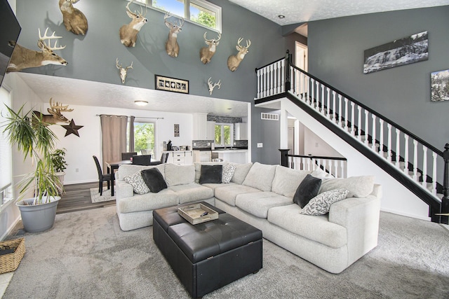 743 Fieldview Dr, Grand Ledge, MI 48837 - living area featuring a high ceiling, baseboards, stairway, and a textured ceiling