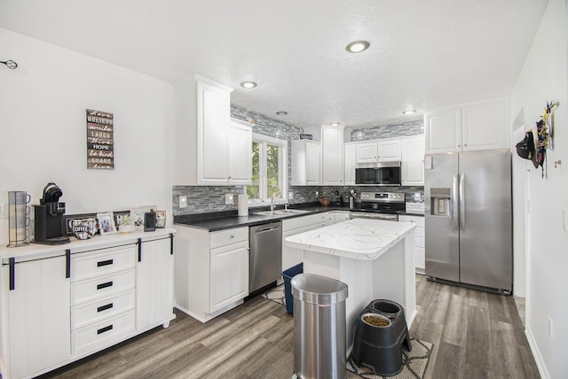743 Fieldview Dr, Grand Ledge, MI 48837 - kitchen with appliances with stainless steel finishes, backsplash, wood finished floors, white cabinets, and a sink