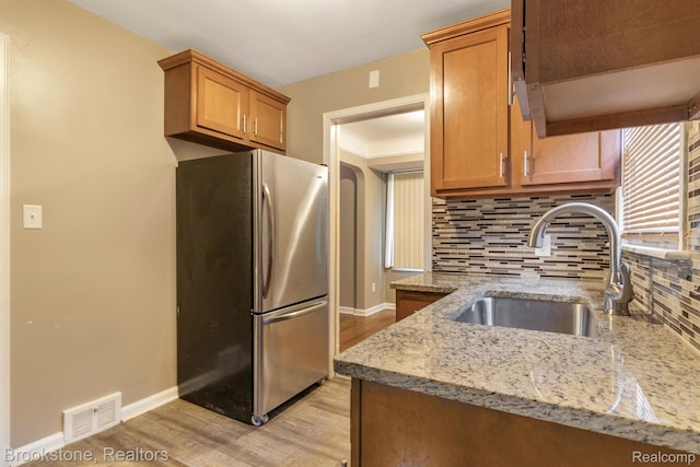 11727 Virgil, Redford, MI 48239 - kitchen featuring freestanding refrigerator, a sink, light wood-type flooring, backsplash, and light stone countertops