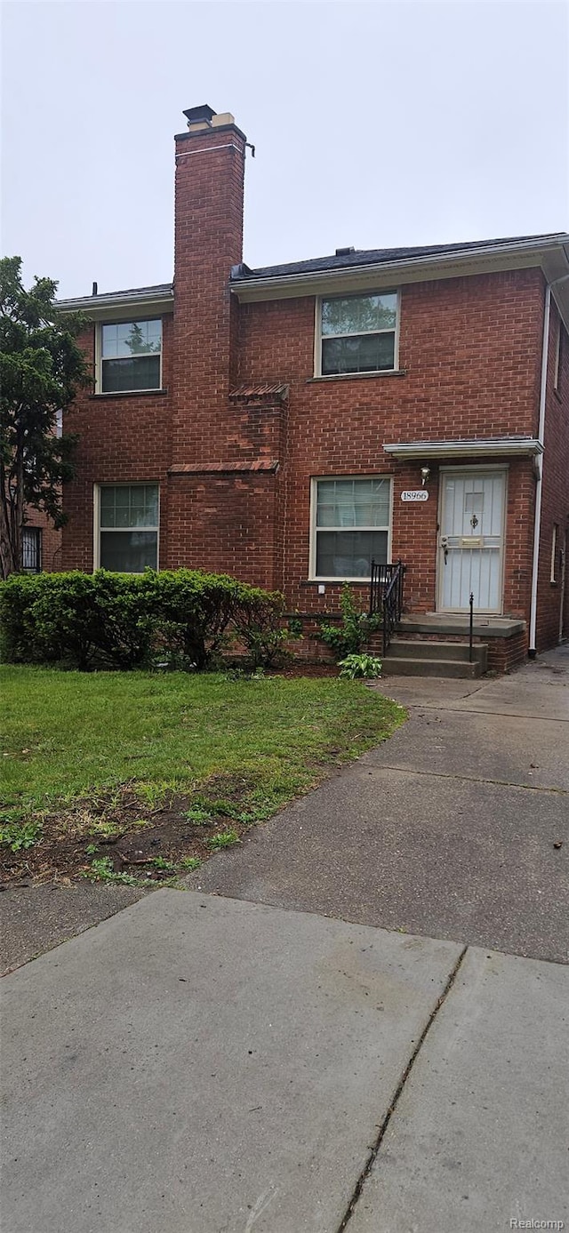 18966 Mendota St, Detroit, MI 48221 - view of front of house featuring a chimney, brick siding, and a front yard