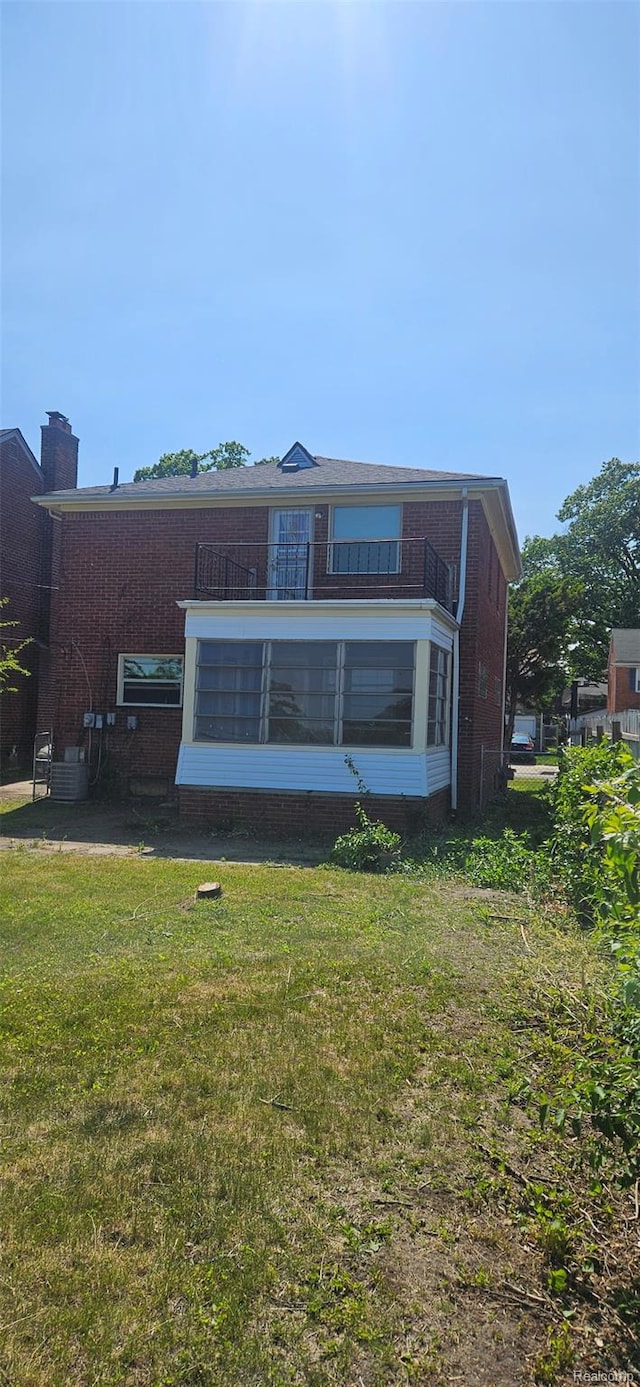 18966 Mendota St, Detroit, MI 48221 - rear view of house featuring a balcony, brick siding, a yard, and a chimney