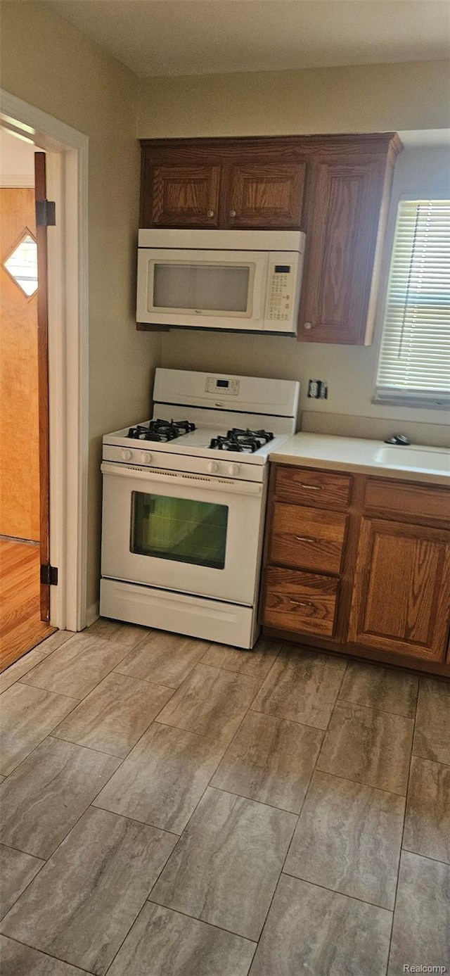 18966 Mendota St, Detroit, MI 48221 - kitchen with white appliances, light countertops, and wood finish floors