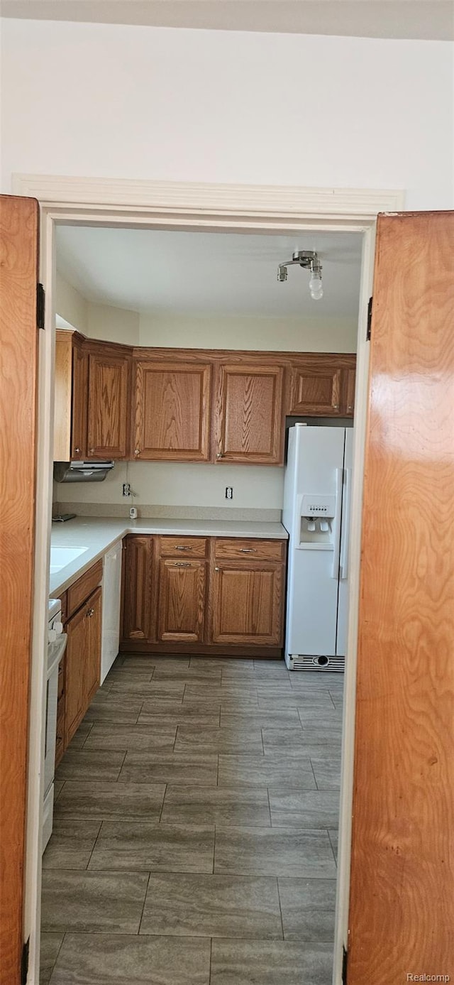 18966 Mendota St, Detroit, MI 48221 - kitchen with white fridge with ice dispenser, wood finish floors, light countertops, brown cabinetry, and dishwasher