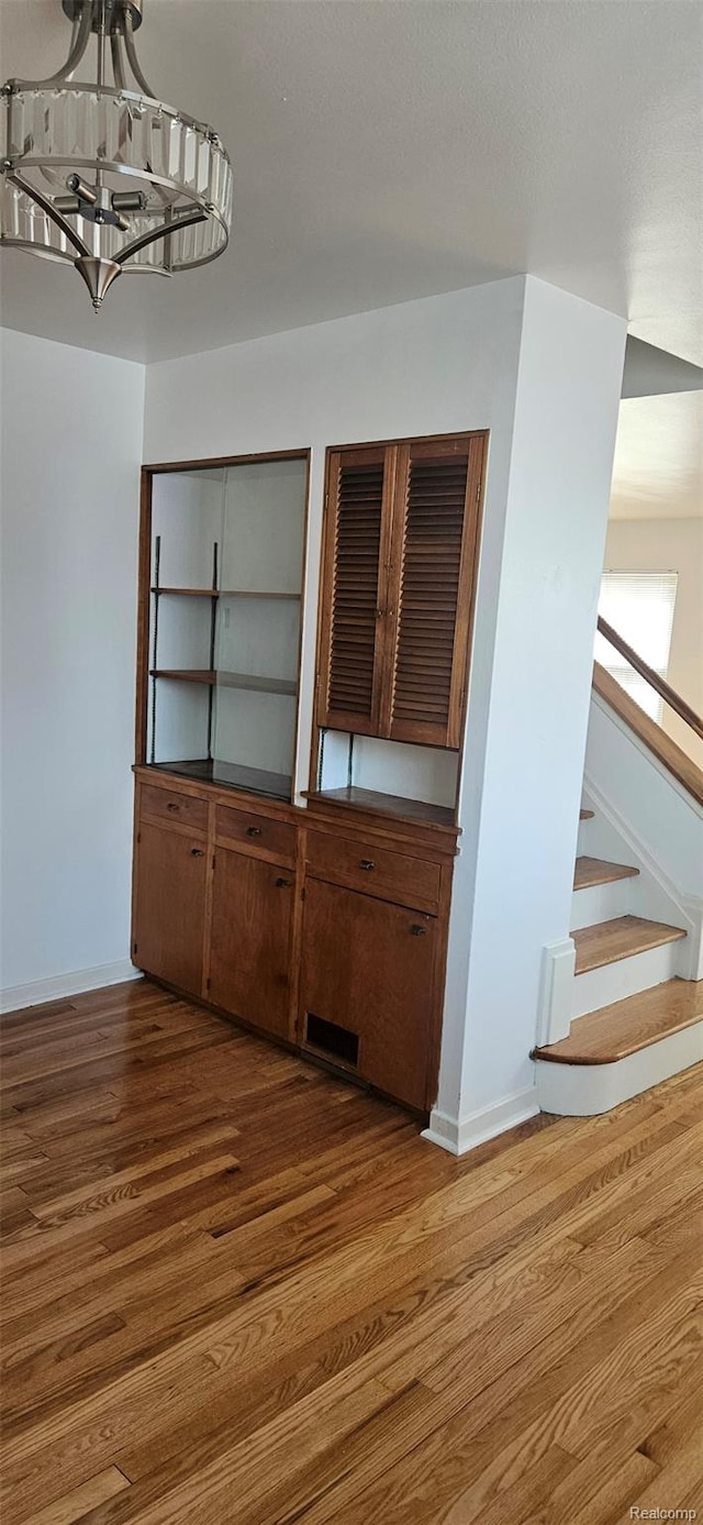 18966 Mendota St, Detroit, MI 48221 - unfurnished dining area featuring wood finished floors, stairs, and a chandelier