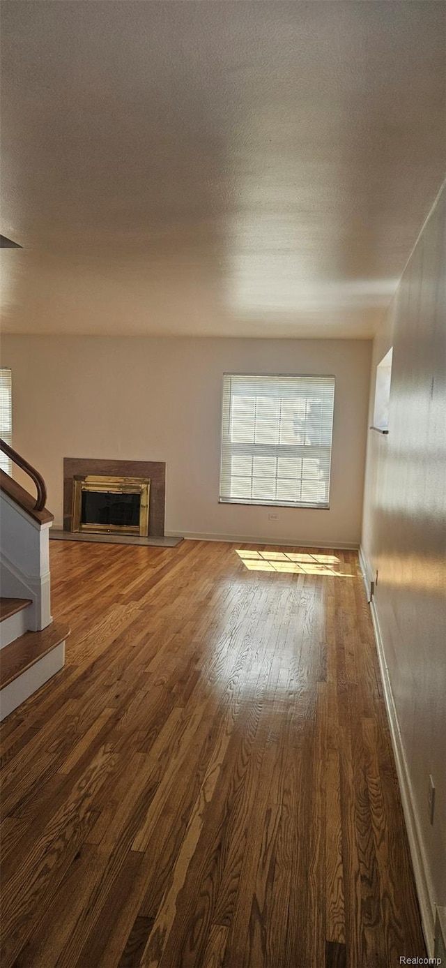 18966 Mendota St, Detroit, MI 48221 - unfurnished living room featuring wood finished floors, stairway, and a fireplace