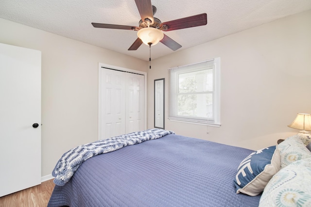 819 Elm St, Manistee, MI 49660 - bedroom featuring wood finished floors, a closet, a ceiling fan, and a textured ceiling