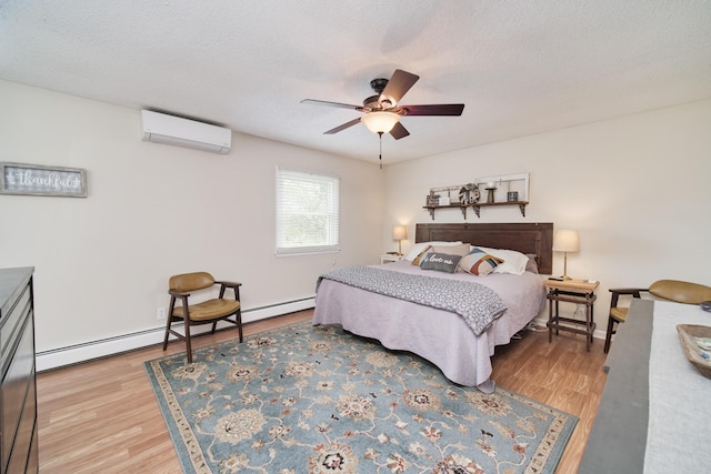 819 Elm St, Manistee, MI 49660 - bedroom with a wall mounted AC, a baseboard heating unit, wood finished floors, a ceiling fan, and a textured ceiling