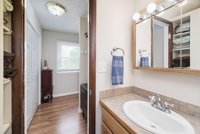 819 Elm St, Manistee, MI 49660 - bathroom with vanity, a closet, wood finished floors, and baseboards