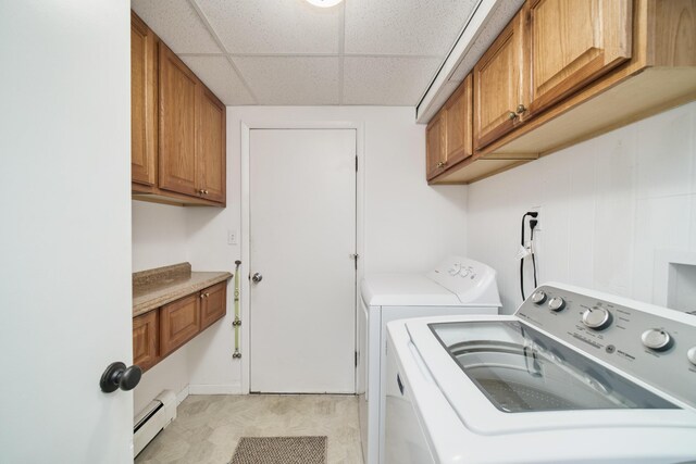 819 Elm St, Manistee, MI 49660 - laundry area with a baseboard radiator, washer and clothes dryer, and cabinet space