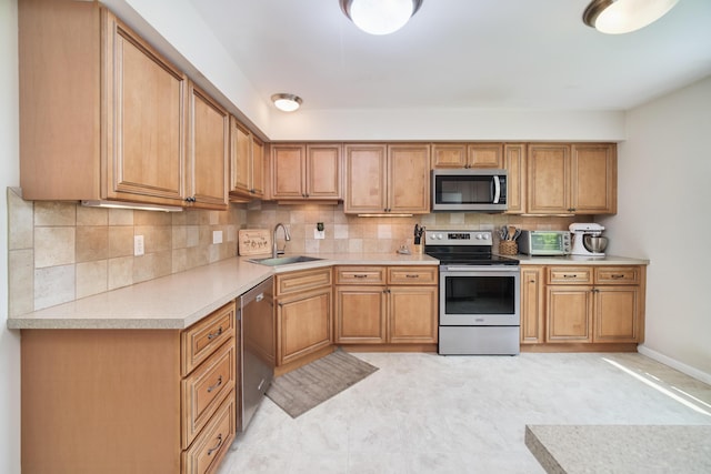 819 Elm St, Manistee, MI 49660 - kitchen with stainless steel appliances, a sink, light countertops, and backsplash