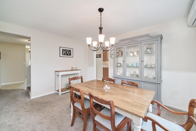 819 Elm St, Manistee, MI 49660 - dining space with a chandelier, light carpet, a wall unit AC, and a textured ceiling