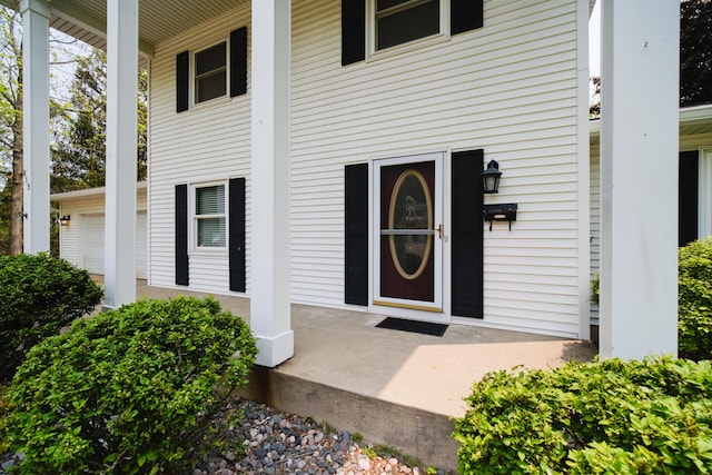 819 Elm St, Manistee, MI 49660 - view of exterior entry with a porch and an attached garage