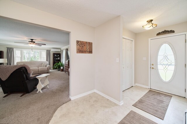 819 Elm St, Manistee, MI 49660 - entryway with an AC wall unit, a textured ceiling, ceiling fan, baseboards, and light tile patterned flooring