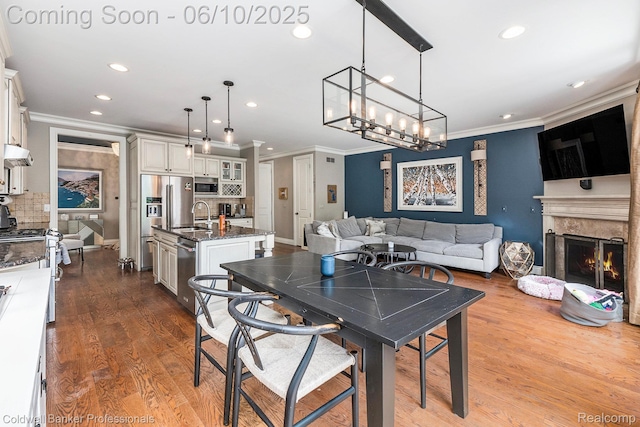 742 Emmons Ave, Birmingham, MI 48009 - dining area with crown molding, recessed lighting, dark wood-style floors, a fireplace, and a chandelier