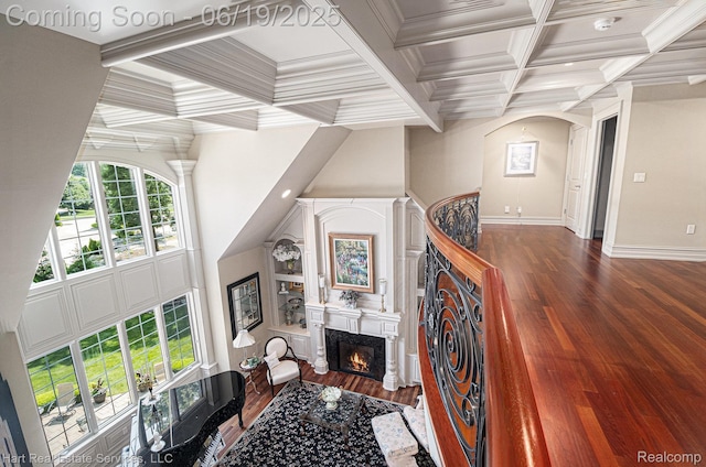 11384 Scarborough Dr, Shelby Twp, MI 48315 - living room with coffered ceiling, wood finished floors, a warm lit fireplace, beam ceiling, and arched walkways
