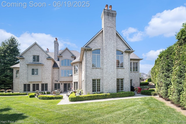 11384 Scarborough Dr, Shelby Twp, MI 48315 - rear view of house featuring a chimney, a yard, brick siding, and a patio
