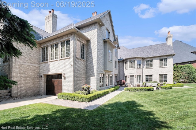 11384 Scarborough Dr, Shelby Twp, MI 48315 - back of house with a yard, brick siding, a garage, concrete driveway, and a chimney