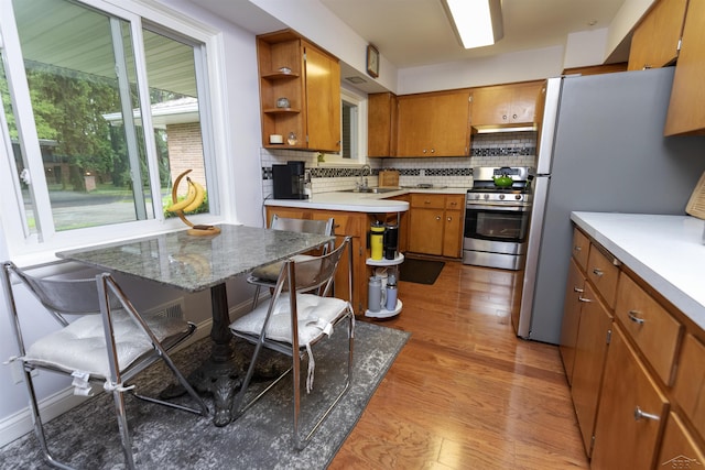 4680 Pinehaven Dr, Saginaw, MI 48638 - kitchen featuring appliances with stainless steel finishes, brown cabinets, open shelves, decorative backsplash, and a sink