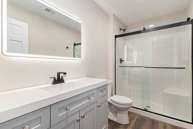 2051 Russell Rd, Muskegon, MI 49445 - bathroom with a stall shower, wood finished floors, toilet, and vanity