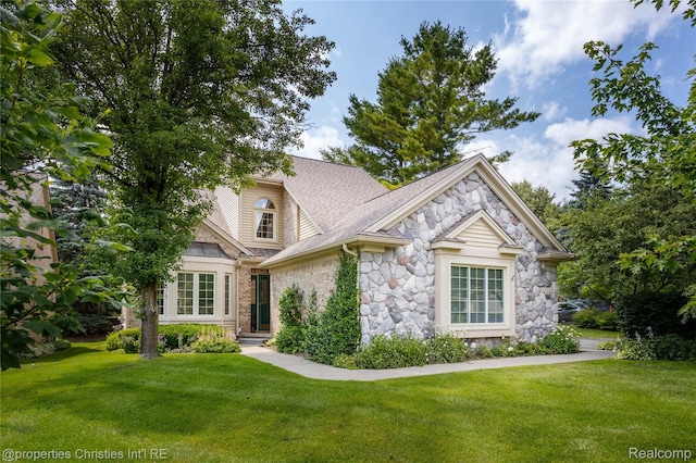 45330 Stonehedge Dr Unit 2, Plymouth, MI 48170 - view of front facade with stone siding, a front yard, and roof with shingles