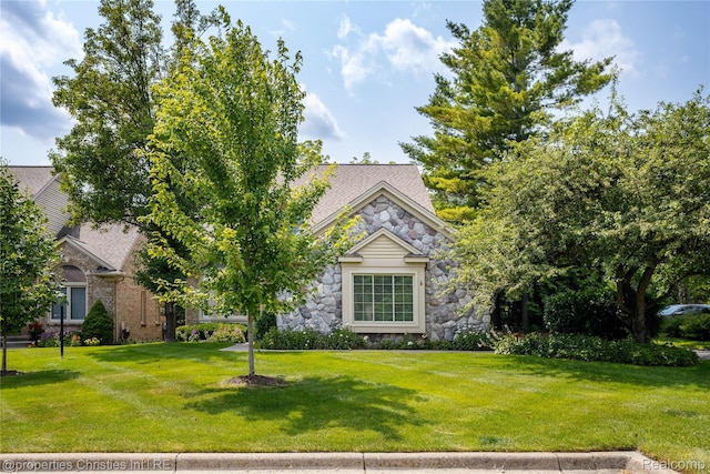 45330 Stonehedge Dr Unit 2, Plymouth, MI 48170 - obstructed view of property featuring stone siding and a front lawn