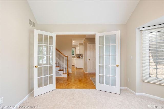 45330 Stonehedge Dr Unit 2, Plymouth, MI 48170 - spare room with lofted ceiling, light carpet, stairs, and french doors