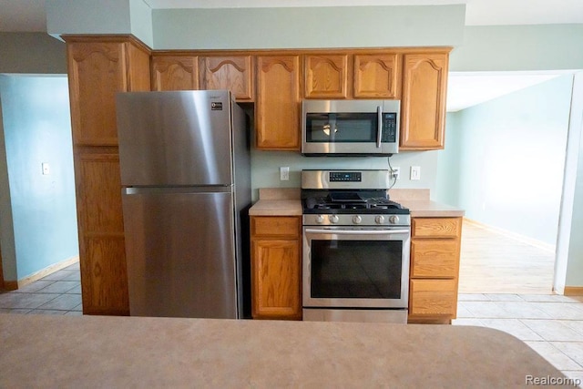 15065 Westlake St, Taylor, MI 48180 - kitchen with stainless steel appliances, light tile patterned floors, light countertops, and brown cabinets