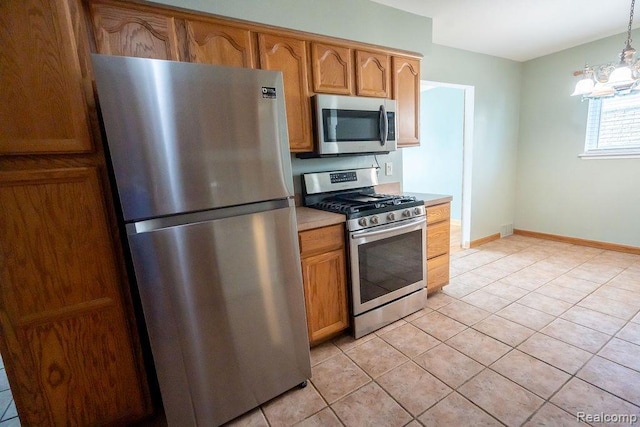 15065 Westlake St, Taylor, MI 48180 - kitchen with appliances with stainless steel finishes, light countertops, light tile patterned floors, pendant lighting, and brown cabinets
