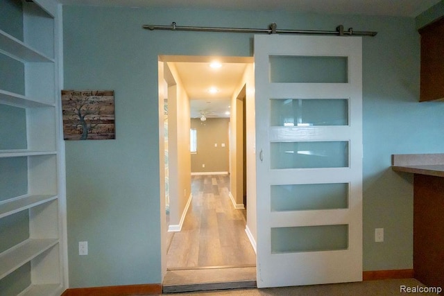 15065 Westlake St, Taylor, MI 48180 - corridor featuring built in features, a barn door, and wood finished floors