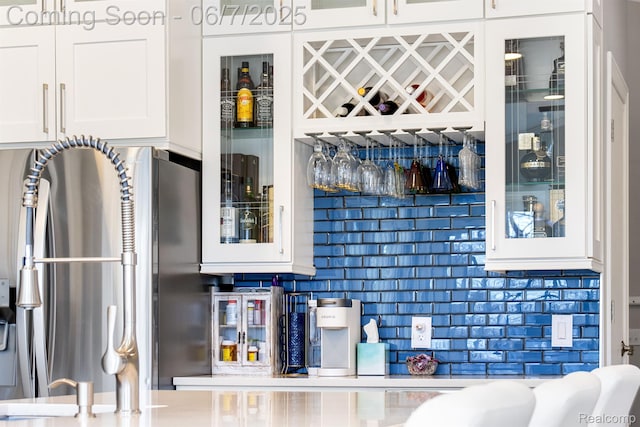 1079 Forest Bay Dr, Waterford, MI 48328 - kitchen featuring glass insert cabinets, white cabinetry, a sink, and decorative backsplash