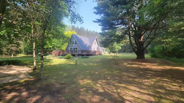 11390 Patterson Rd, Ravenna, MI 49451 - view of grassy yard with a deck and a forest view