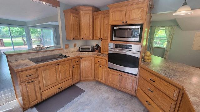 11390 Patterson Rd, Ravenna, MI 49451 - kitchen with stainless steel appliances, a peninsula, and pendant lighting