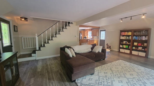 11390 Patterson Rd, Ravenna, MI 49451 - living room featuring stairs, wood finished floors, baseboards, and rail lighting
