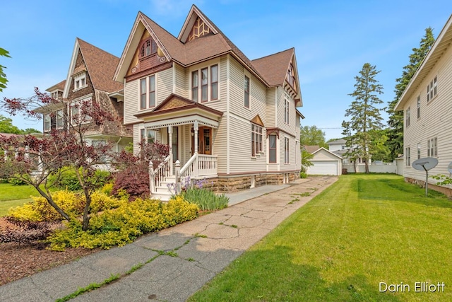 216 E Main St, Ionia, MI 48846 - view of front of house with a garage, a front yard, an outbuilding, and a shingled roof
