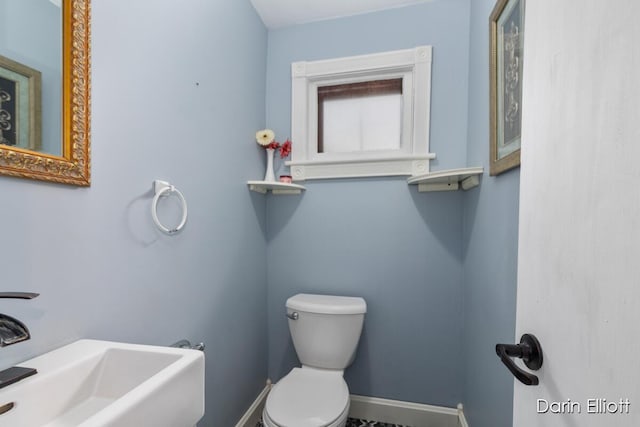 216 E Main St, Ionia, MI 48846 - bathroom with toilet, a sink, and baseboards