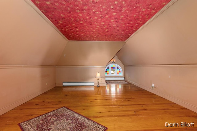 216 E Main St, Ionia, MI 48846 - additional living space with a baseboard heating unit, wood finished floors, baseboards, and vaulted ceiling
