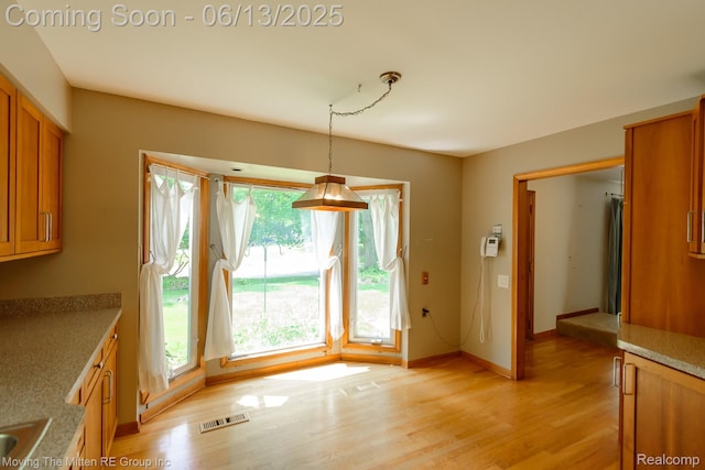 5590 Bayswater Rd, West Bloomfield, MI 48322 - unfurnished dining area featuring light wood-style flooring and baseboards