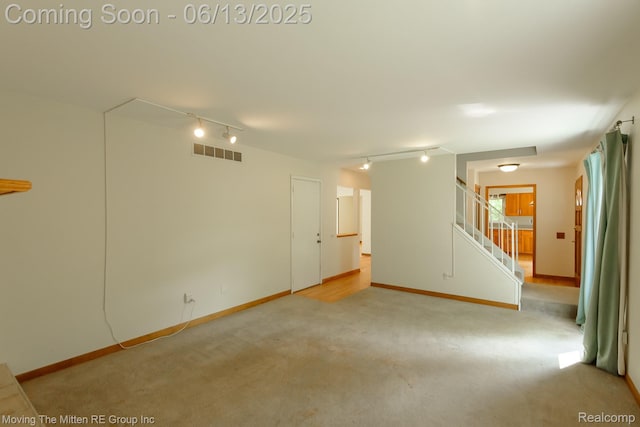 5590 Bayswater Rd, West Bloomfield, MI 48322 - carpeted spare room featuring rail lighting and stairs