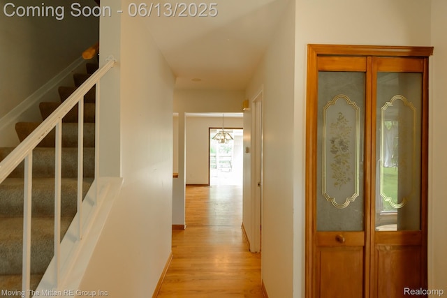 5590 Bayswater Rd, West Bloomfield, MI 48322 - hall with light wood-style floors, stairway, and a chandelier