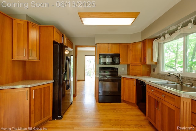 5590 Bayswater Rd, West Bloomfield, MI 48322 - kitchen featuring black appliances, light countertops, brown cabinets, and light wood-type flooring
