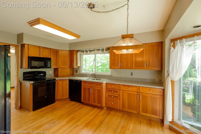 5590 Bayswater Rd, West Bloomfield, MI 48322 - kitchen with black appliances, light countertops, brown cabinets, light wood-style floors, and pendant lighting