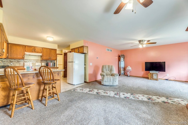 1908 Grant Pl, Port Huron, MI 48060 - kitchen featuring freestanding refrigerator, a ceiling fan, brown cabinetry, and a peninsula