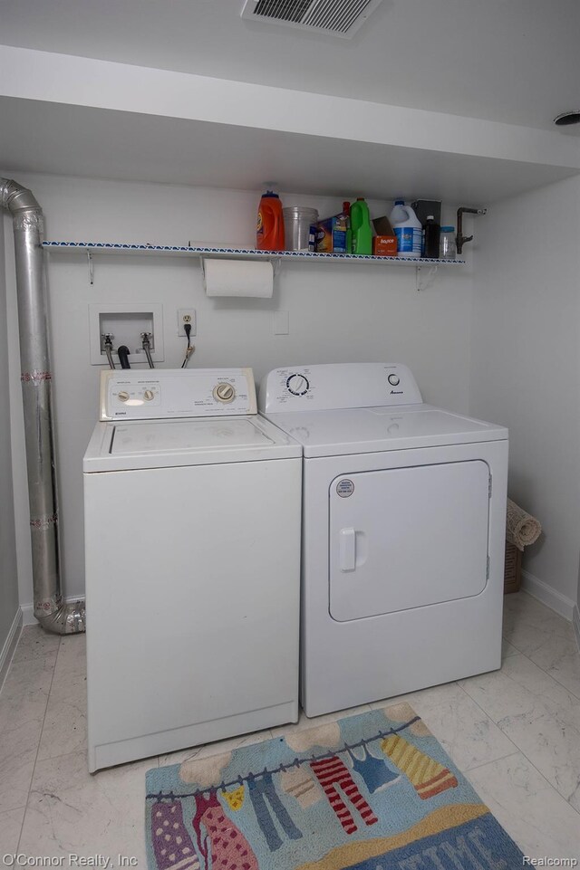 105 Gratiot Blvd, Marysville, MI 48040 - washroom with light marble finish flooring, washing machine and clothes dryer, and baseboards