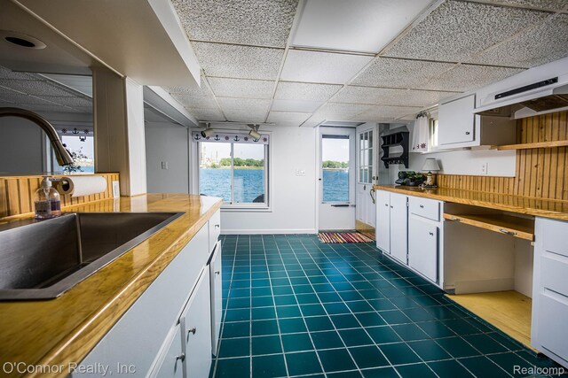 105 Gratiot Blvd, Marysville, MI 48040 - kitchen featuring a sink, white cabinets, dark tile patterned flooring, and a paneled ceiling