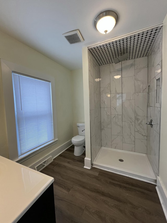 846 Lafayette Ave NE, Grand Rapids, MI 49503 - full bathroom featuring toilet, tiled shower, baseboards, and wood finished floors