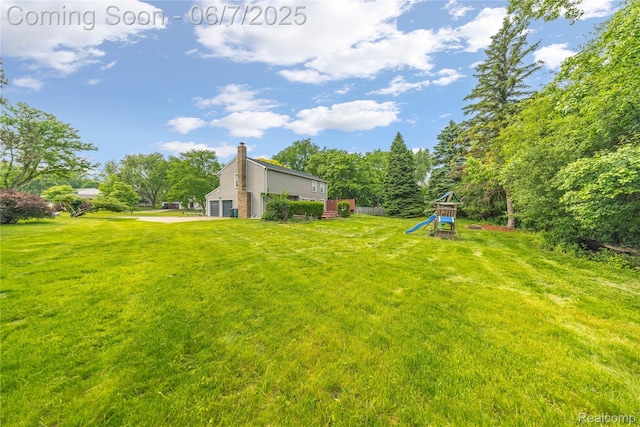 1633 Fleetwood Dr, Troy, MI 48098 - view of green lawn featuring a playground, a garage, and driveway